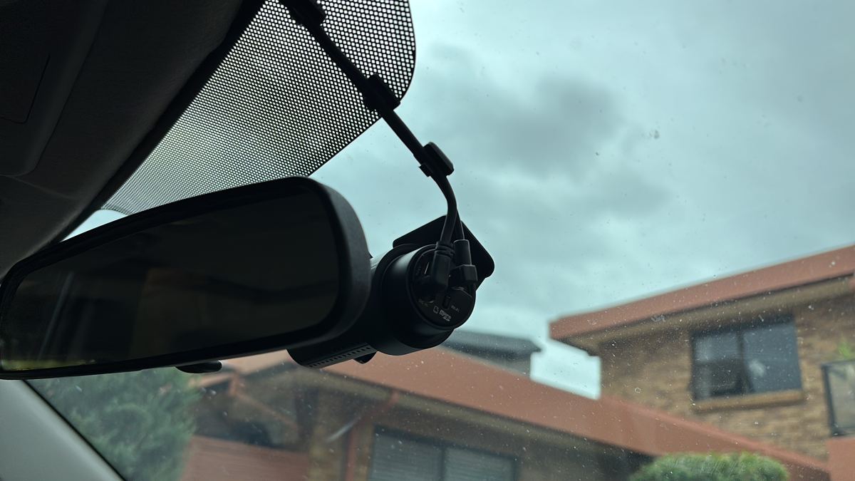 Dashcam mounted neatly beside the rear-view mirror after installation